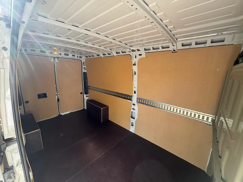 Interior de la caja de carga con paredes forradas y raíles de amarre a media altura