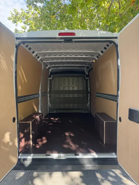 Puertas traseras abiertas: caja de carga forrada en madera con raíles de amarre
